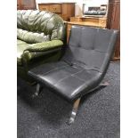 A retro style black leather lounge chair on chrome legs