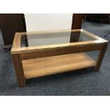 A contemporary walnut two-tier glass topped coffee table