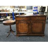 An inlaid mahogany double door sideboard together with a circular drum table