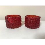 A pair of ruby red Whitefriars cylindrical bark candle holders designed by Geoffrey Baxter,