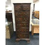 A walnut seven-drawer chest with brass drop handles on bracket feet