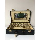 A vintage travel case containing a dressing table set