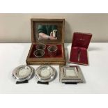 An inlaid trinket box containing plated picture frames, napkin rings,