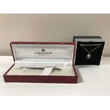 A boxed Van Peterson silver necklace together with a boxed Caran D'ache pen