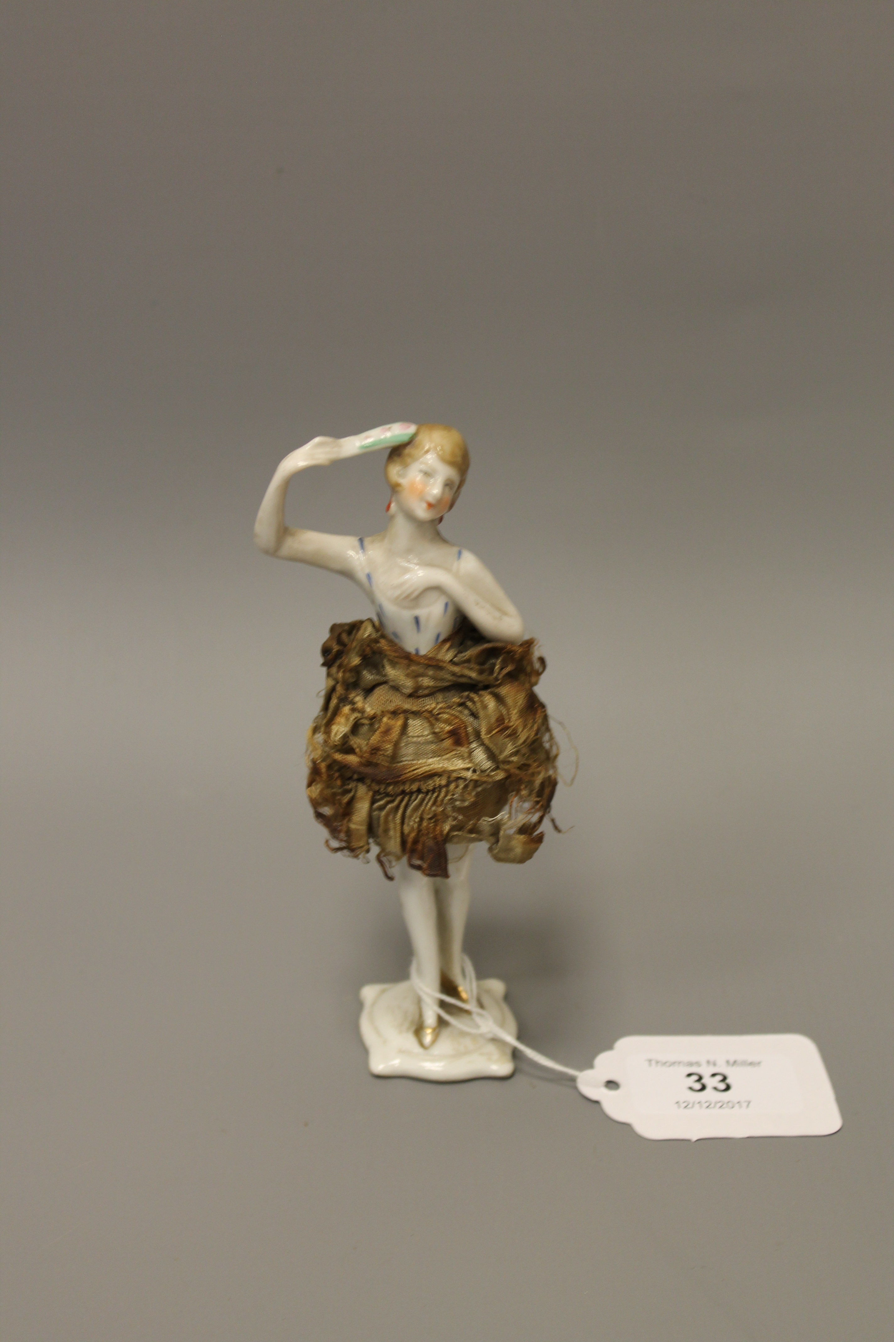 A nineteenth century German porcelain doll pincushion figure