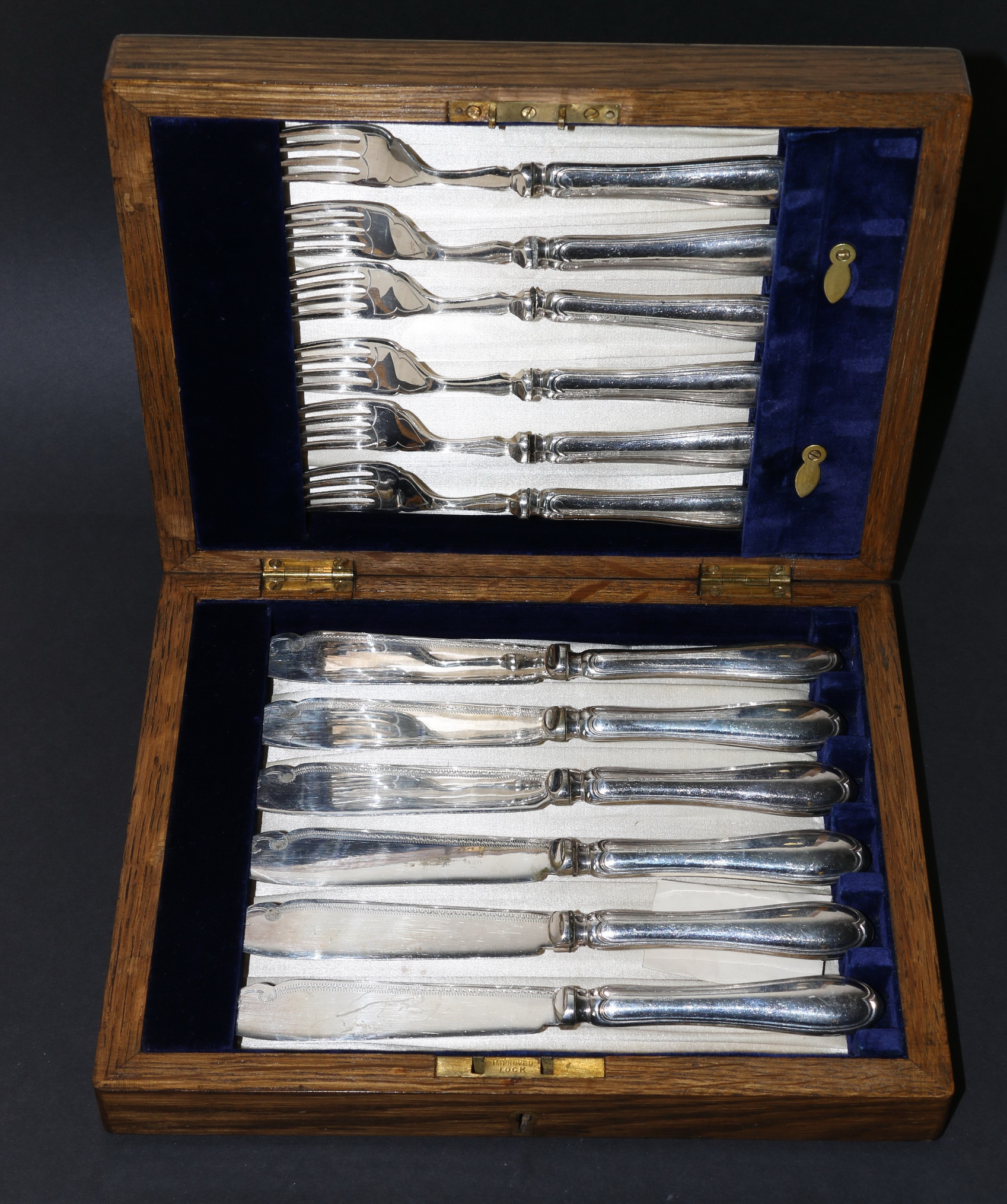 Set of twelve close plated fruit knives and forks with embossed silver handles,