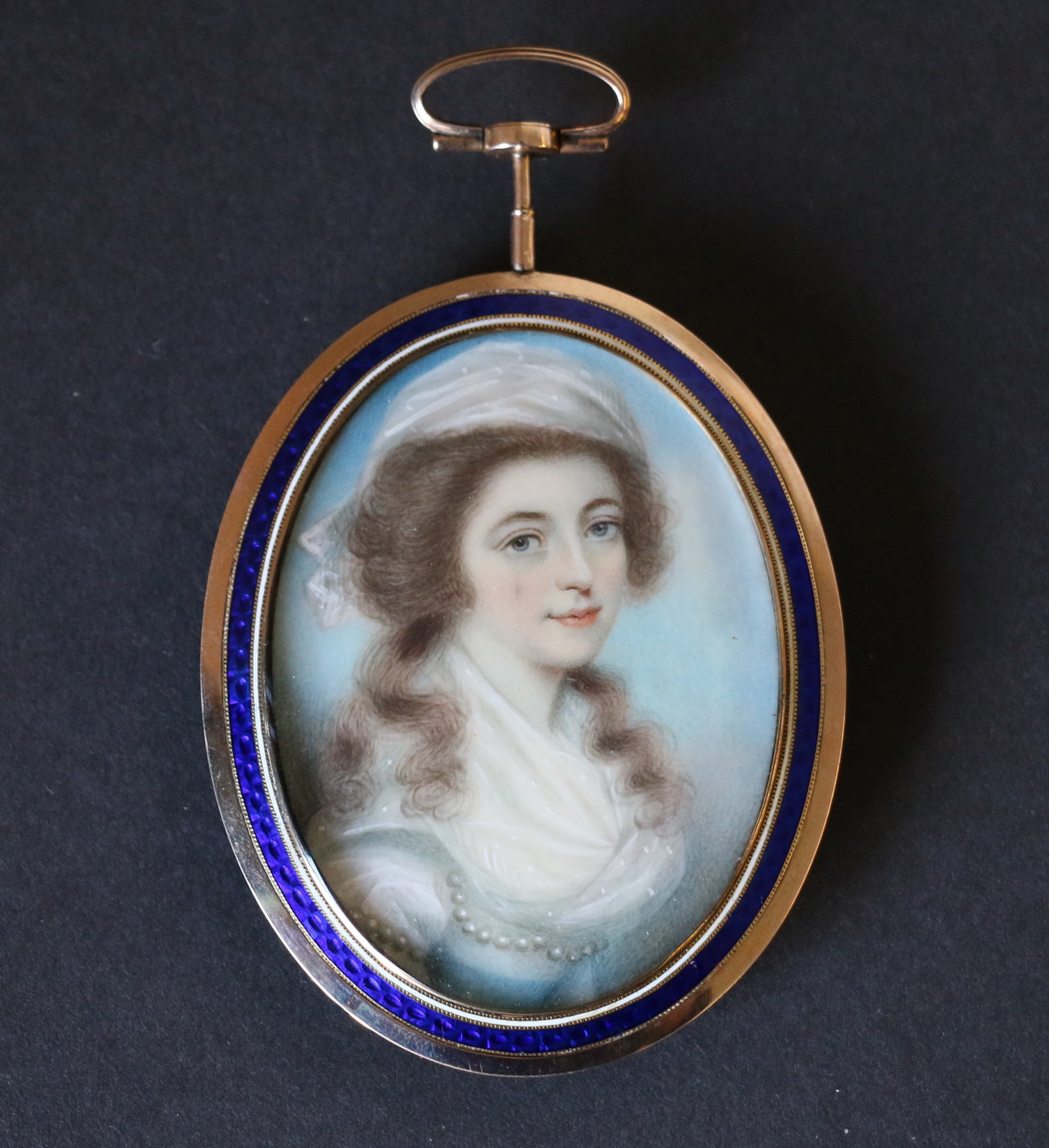 Late 18th century miniature portrait of a young woman with white bodice, bonnet & pearls,