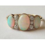 Ring with three graduated oval opals separated by six diamonds millegrain-set in gold,