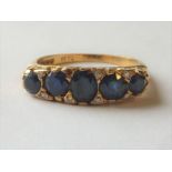 Half hoop ring with five graduated sapphires and tiny diamond brilliants in 18ct gold, 1974.