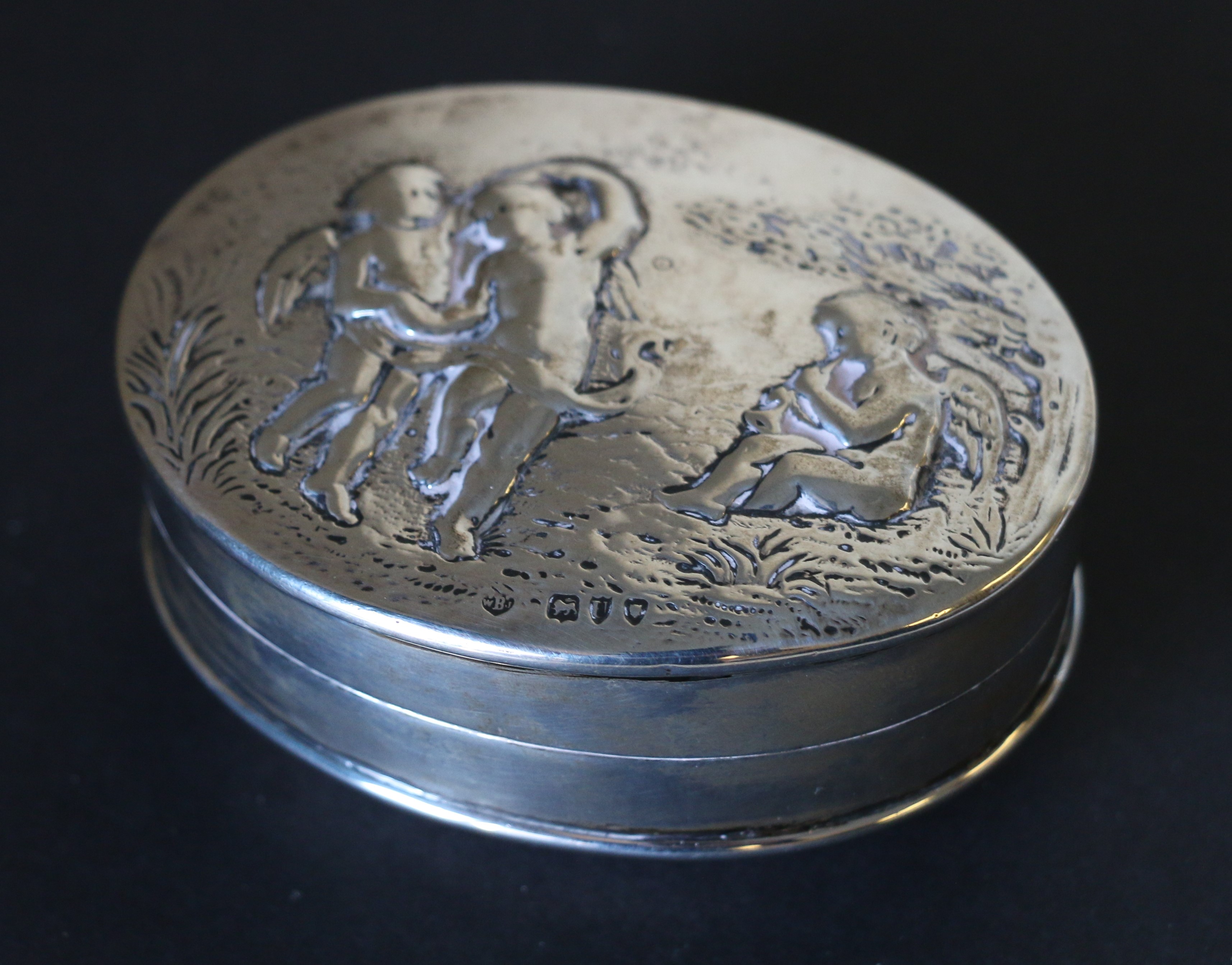 Edwardian silver oval box, the embossed cover with infant dancers by Barnards, 1895,