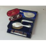 Silver four piece brush set and a spoon and fork, cased.