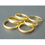 Six 22ct gold band rings.