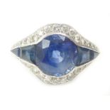 Ring with a circular sapphire flanked by four others,