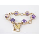 9ct curb bracelet with six amethysts in openwork claw mounts.