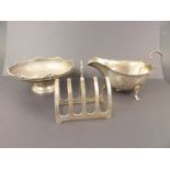 Silver sauce boat, toast rack and shallow dish with scroll edge. (3) Condition Report.