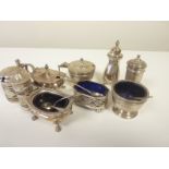 Silver three piece condiment set with waved piercing, another tapering and a similar e.p. set.