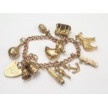 Gold curb bracelet with woodpecker, joiners plane and other charms. Condition Report.