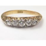 Edwardian five stone diamond ring with graduated brilliants in carved gold, "18ct", Size "N1/2".