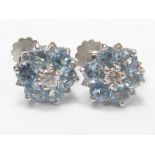Pair of aquamarine and diamond circular cluster earrings, the brilliant at the centre.