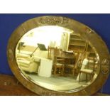 Arts and Crafts bevel edged oval wall mirror with beaten copper frame.