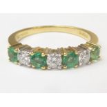 Diamond and emerald seven stone ring in 18ct gold, size "M".