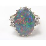 Opal ring with oval doublet flanked by four diamonds in white gold probably "750".