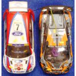 Two large scale remote control cars, Ford Focus Rally Car and another with aerofoil,
