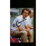 FOOTBALL, signed colour postcard by Franz Beckenbauer, full-length seated as West Germany coach, EX