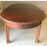 Warring and Gillows mahogany extending dining table on tapered legs with brass casters, carved