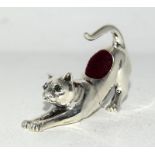 a cast sterling silver pincushion in the form of a cat with emerald eyes