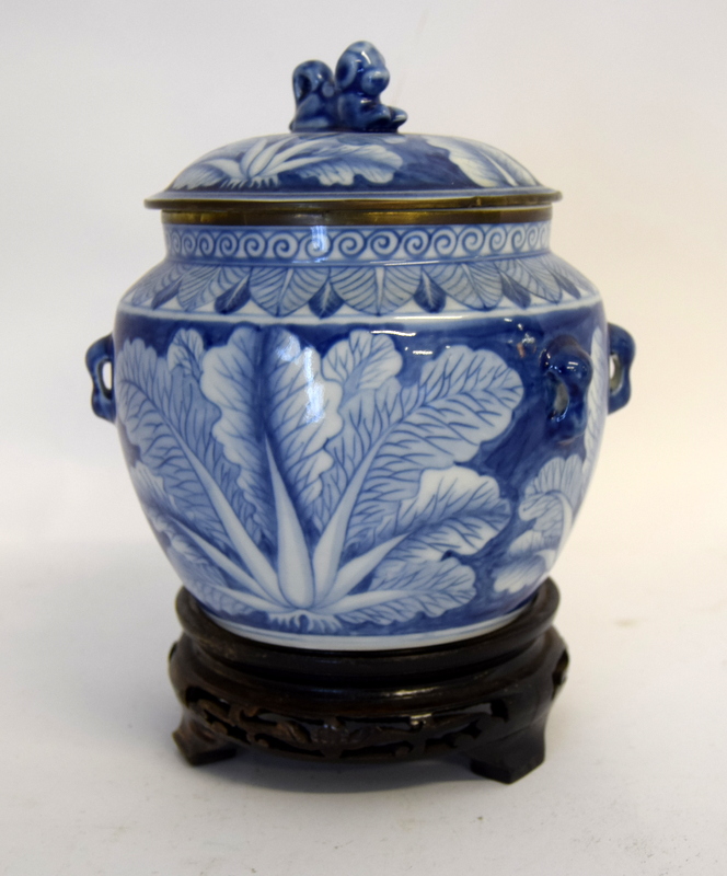 Oriental blue and white decorated jar and cover on a carved wooden stand