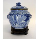 Oriental blue and white decorated jar and cover on a carved wooden stand