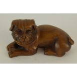 a Japanese carved wooden netsuke in the form of a dog signed to the base