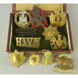 An old cigar box containing a quantity of Military badges