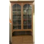 Oak tall glassed door bookcase with adjustable shelves over 2 small lower cupboards 220x110x35cm