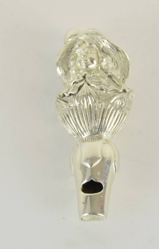 an unusual silver whistle in the shape of a young lady with a bonnet