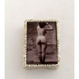 a silver plated pill box with nude image to the lid