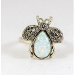 a silver and opal ring in the form of a lady bird