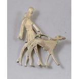 a silver art deco brooch depicting a lady walking her dog