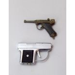 A novelty petrol lighter in the form of a derringer pistol 7.5cms long and a miniature cap firing