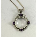 a silver magnifying glass pendant necklace set with amethysts