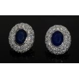 a pair of silver cz and sapphire cluster earrings