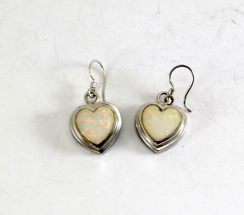 a pair of silver and opal heart shaped earrings