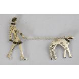a silver art deco brooch in the form of a lady walking her dog