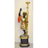 A carved wood Blackmore figure holding a lamp. 176cm tall