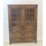 Oak glassed top bookcase over 2 cupboards with carved decoration and adjustable shelves 135x30x35cm