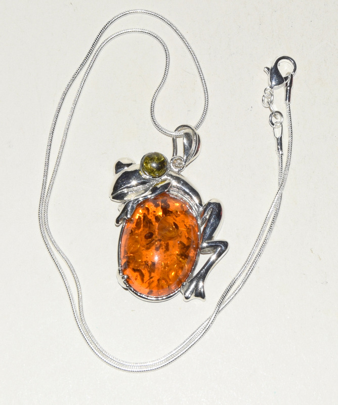 A silver amber style frog shaped pendant necklace on silver chain