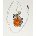 A silver amber style frog shaped pendant necklace on silver chain
