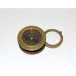A brass compass with integral magnifying glass made by T Cook & Sons