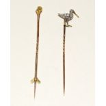 Two yellow metal stick pins. One in the form of a bird diamond set